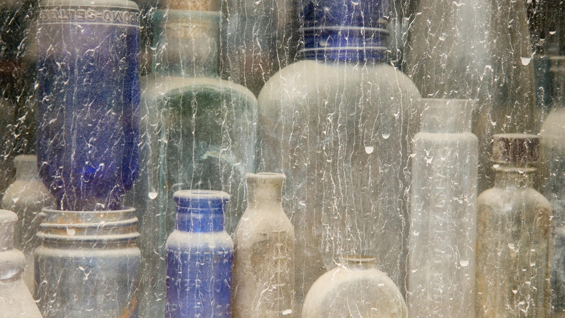 old bottles behind cracked glass