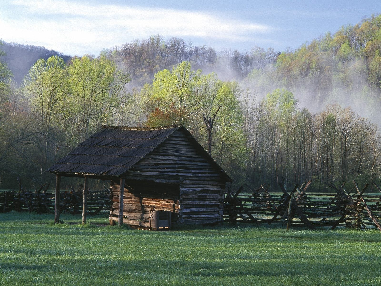 Old cabin in a misty valley