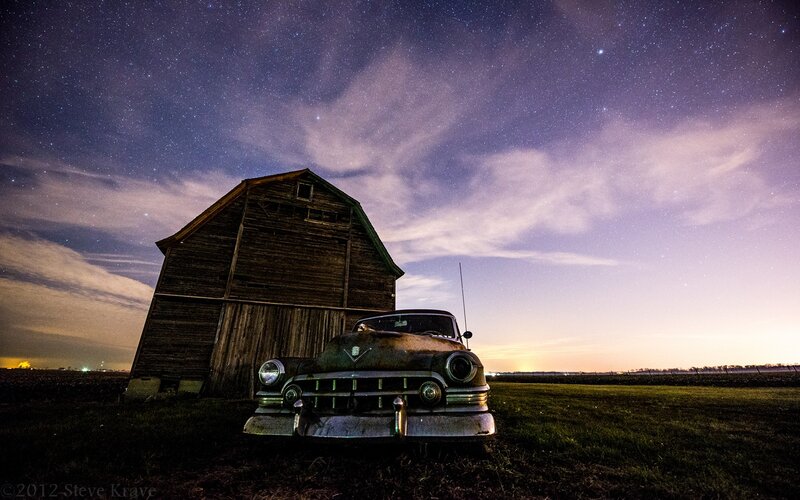 Old car under starry sky