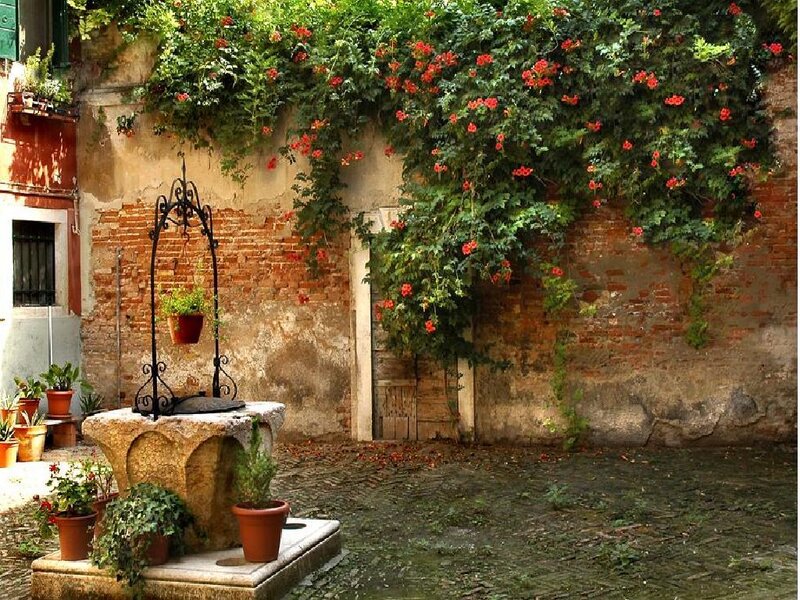 Old courtyard with fountain and flowers