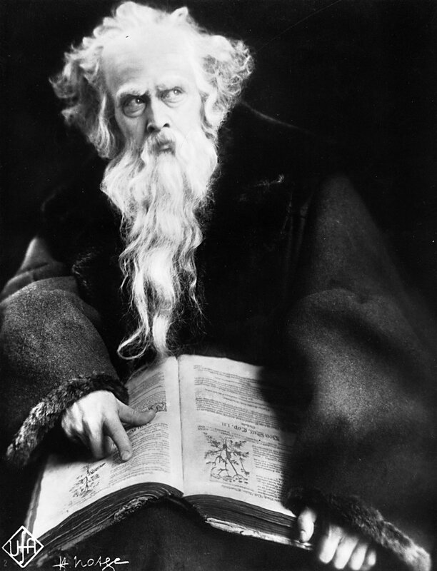 Old man with long beard reading book