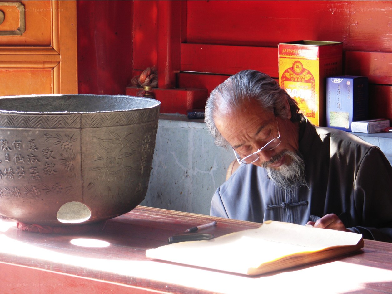 Old man writing in a temple