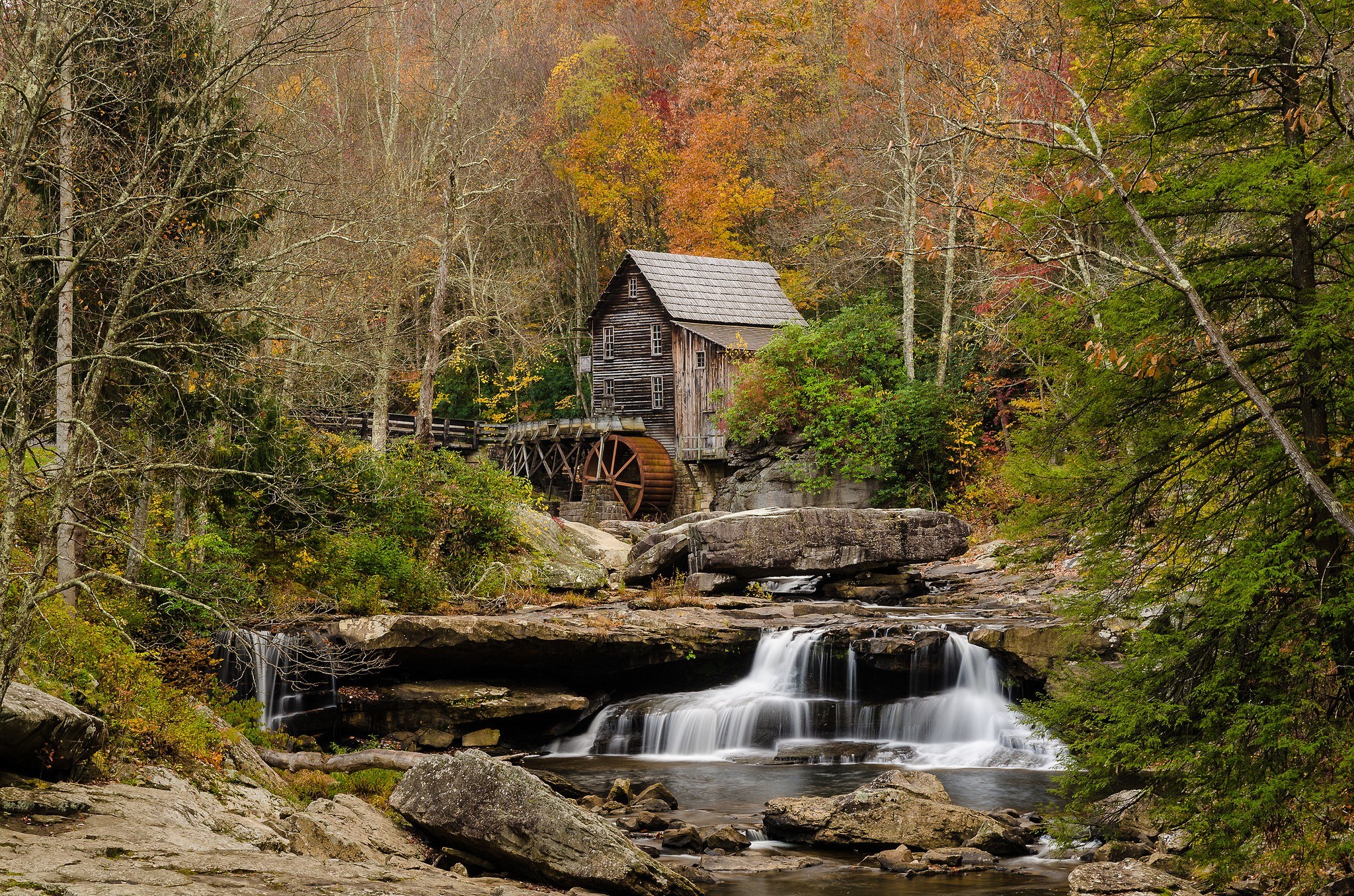 Old mill by a waterfall in autumn