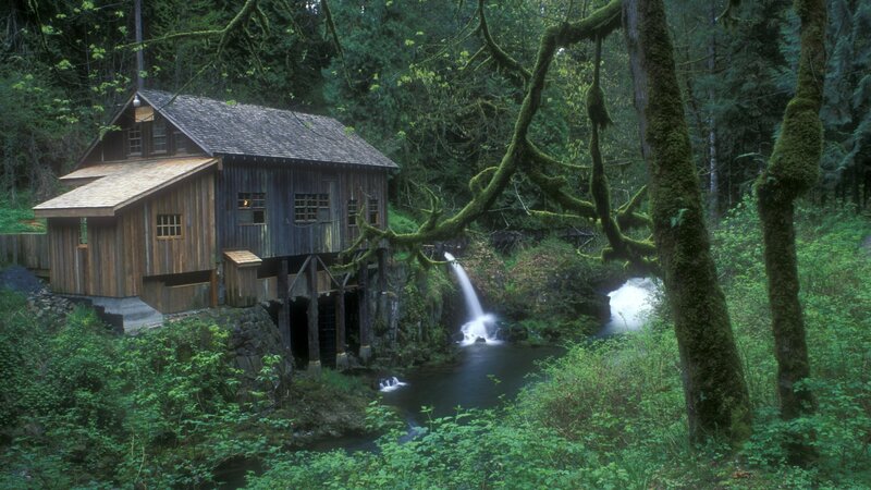 Old mill by forest waterfall