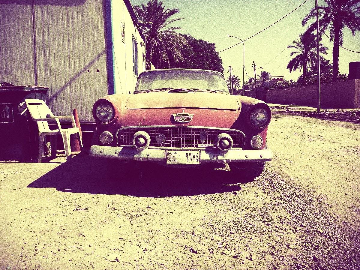 Old red car on a dirt road
