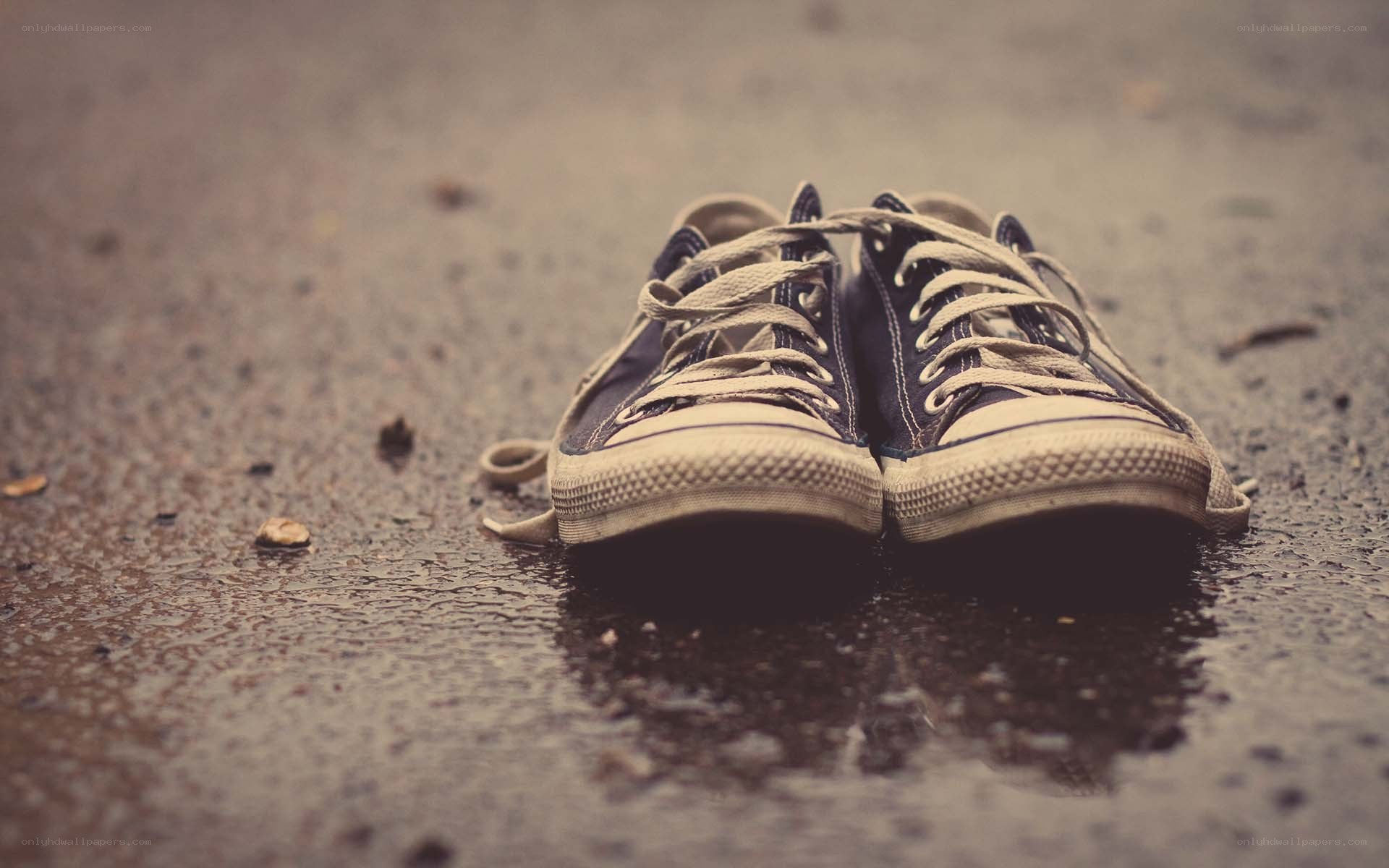 old sneakers on wet pavement