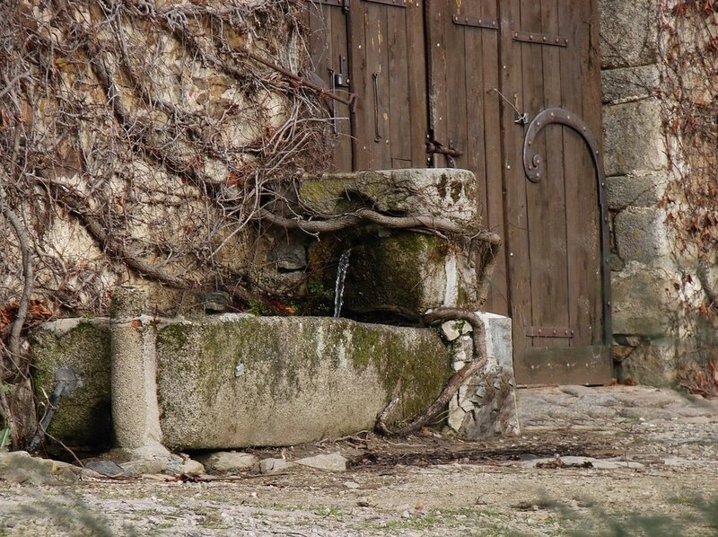 Old stone fountain by wooden door