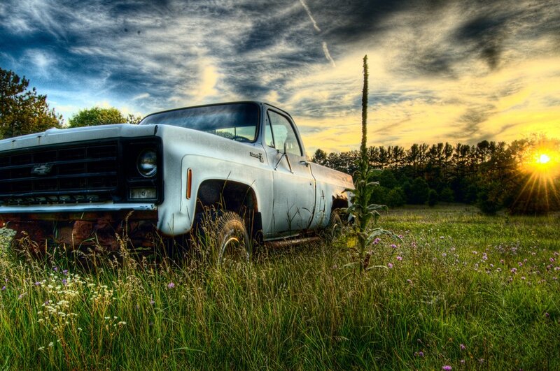 Old truck in a field at sunset