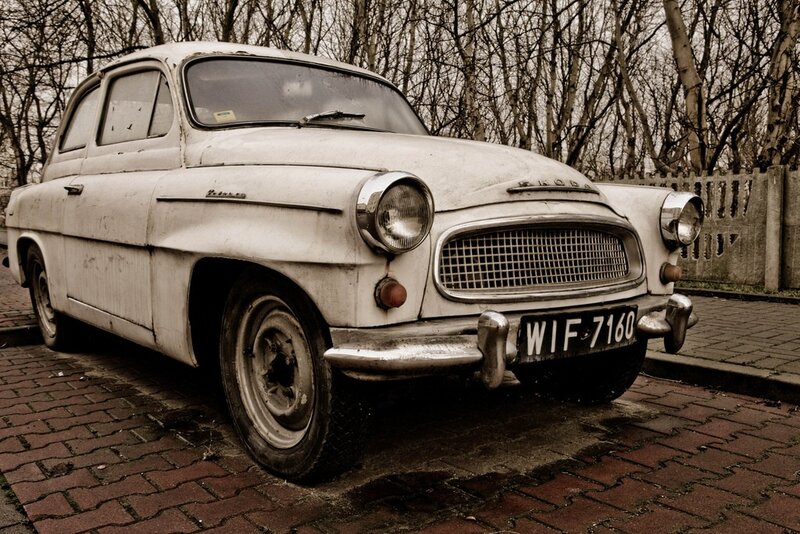 Old white Skoda parked on bricks