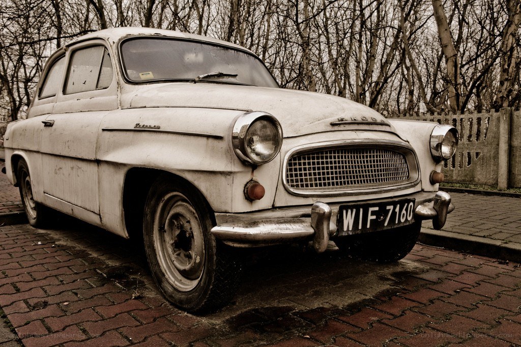Old white Skoda parked on bricks