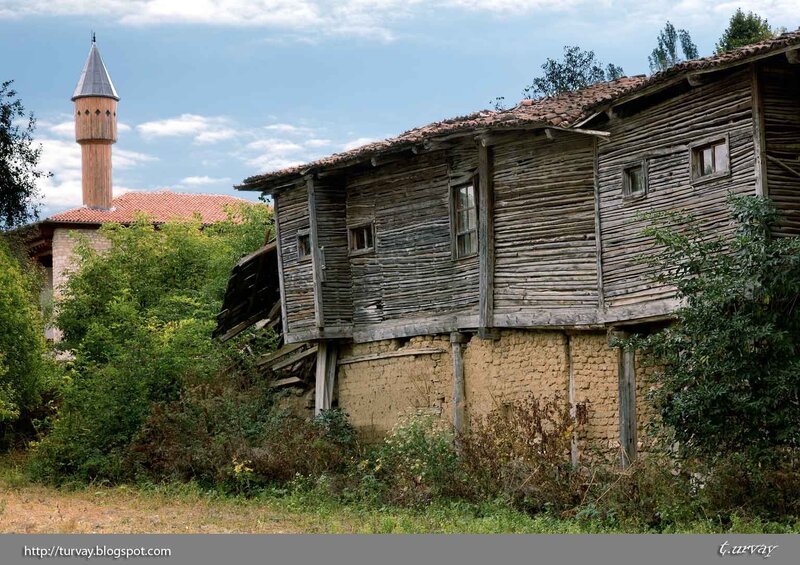 Old wooden house with mosque minaret