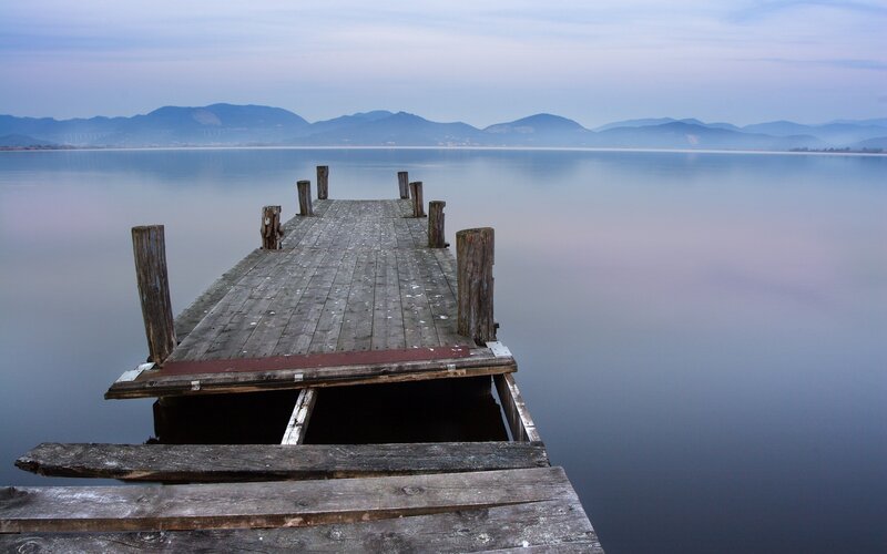 Old wooden pier on calm lake