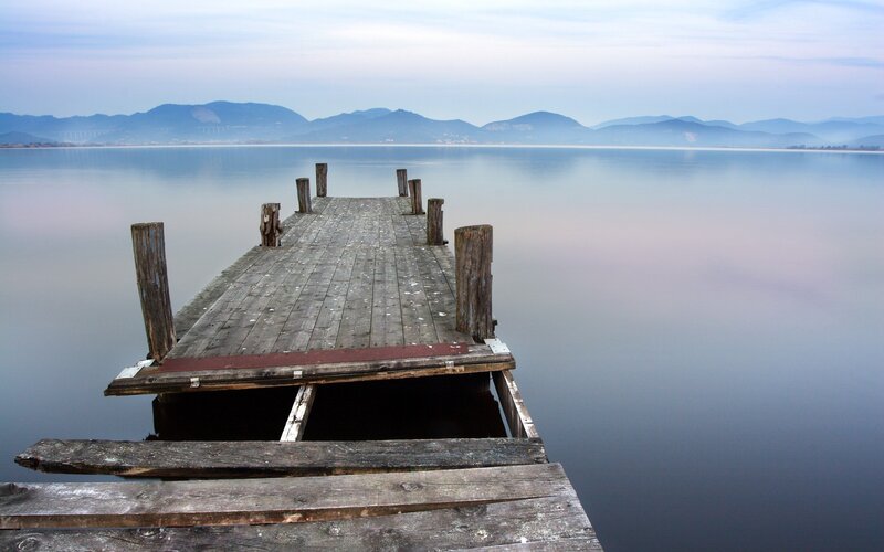 Old wooden pier on calm lake