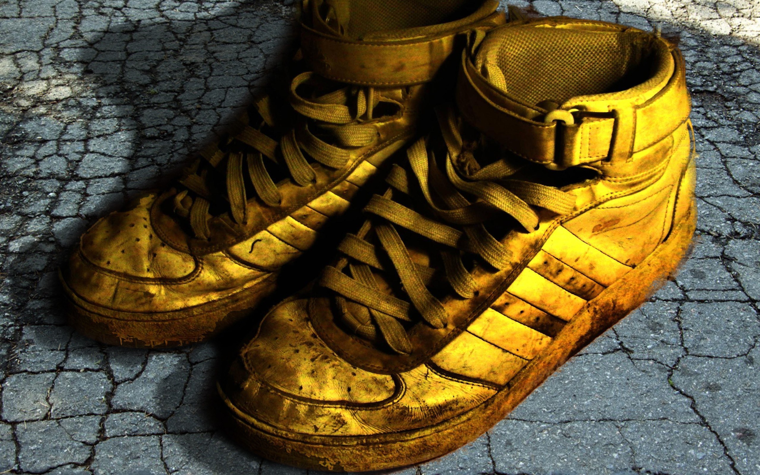old yellow sneakers on pavement