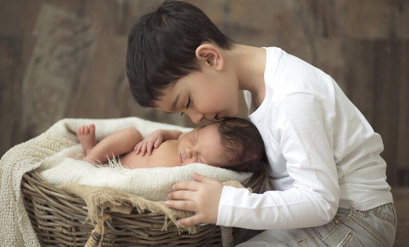Older Boy Kissing Baby