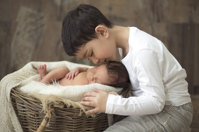Older Boy Kissing Baby — White