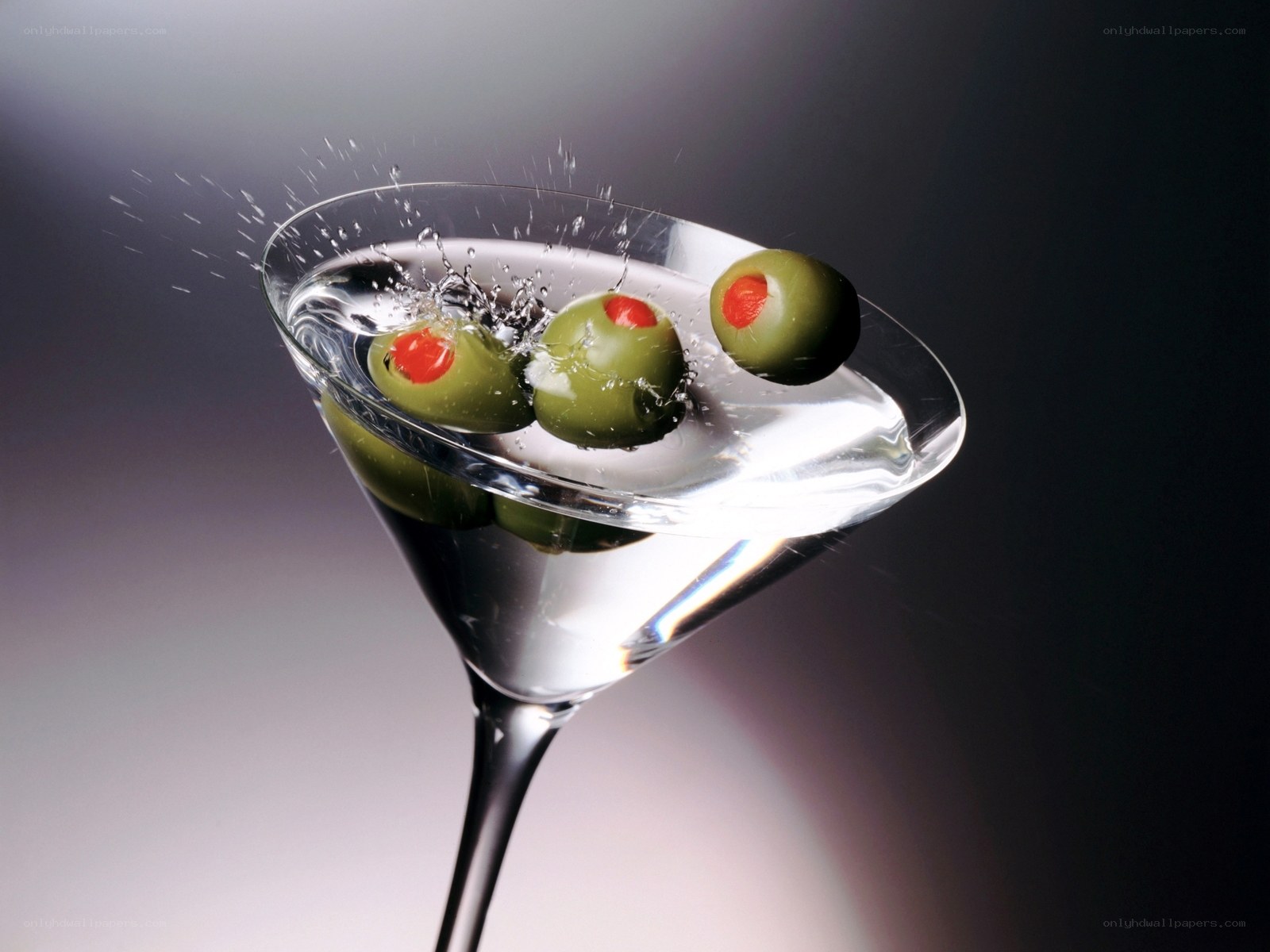 olives splashing in martini