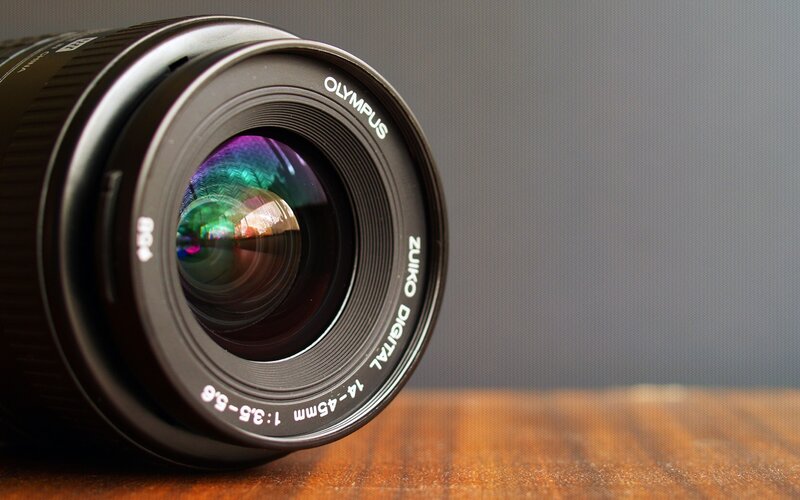 Olympus Zuiko lens on wood