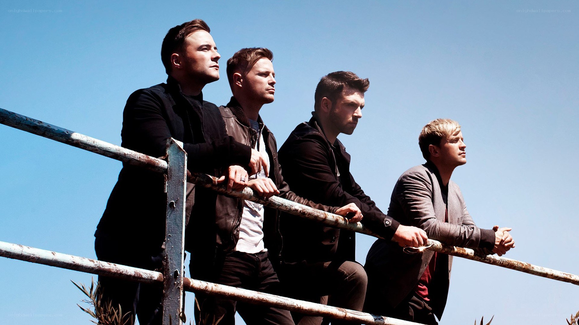One Direction band members on a railing