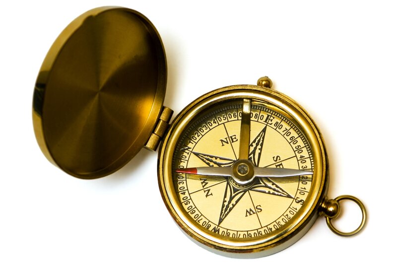 open brass compass on white