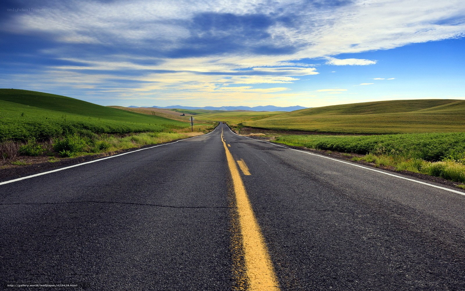 Open road through green hills