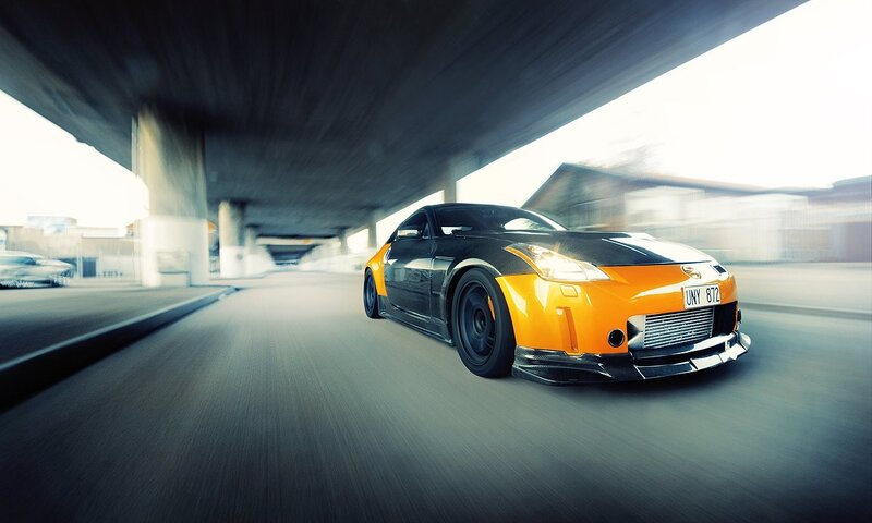 Orange and black sports car driving