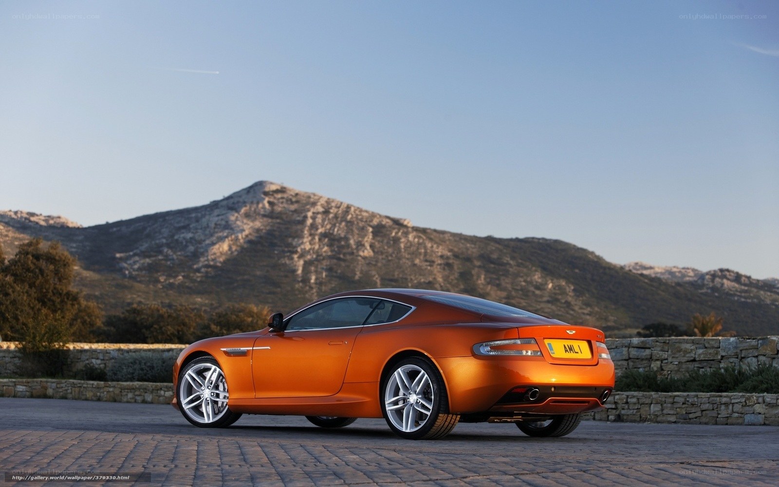 Orange Aston Martin on a mountain road