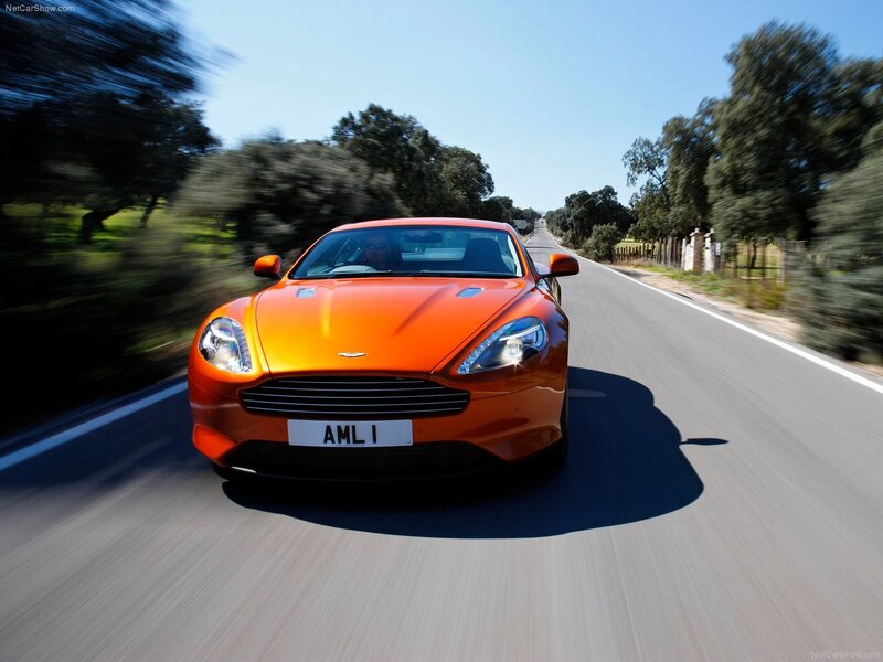 orange Aston Martin on country road