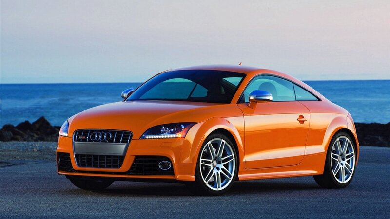 Orange Audi TT parked by the sea