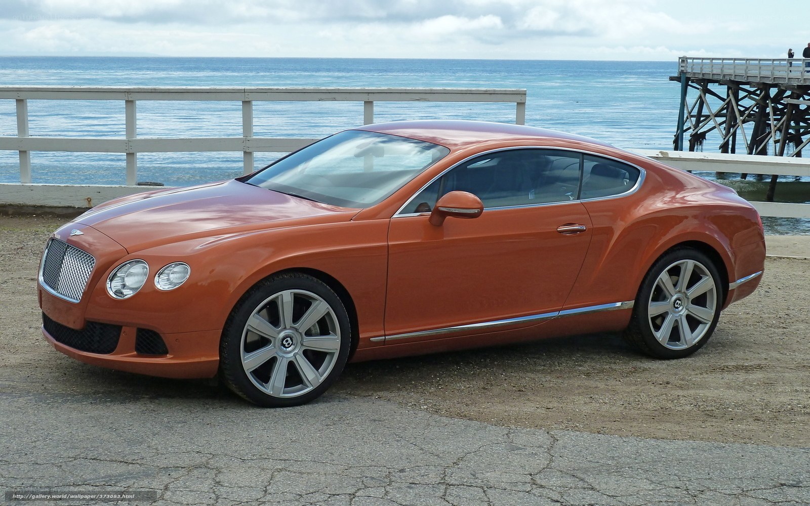Orange Bentley near the ocean