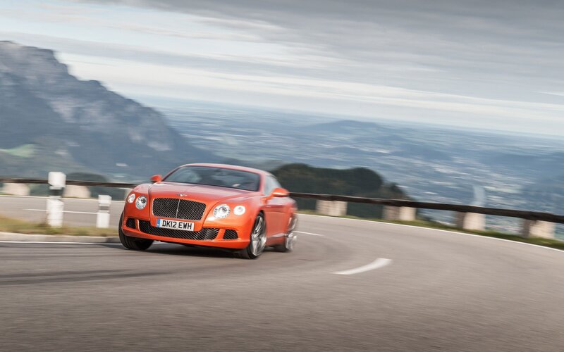 Orange Bentley on mountain road
