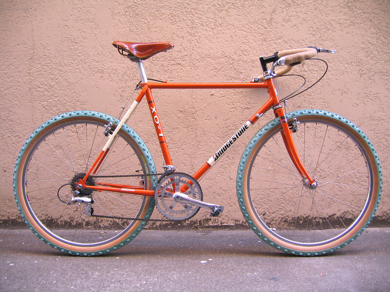 orange bicycle with tan tires