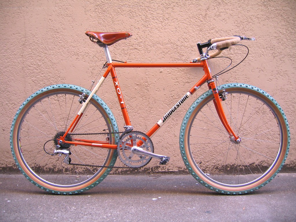 orange bicycle with tan tires