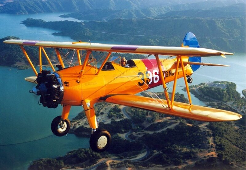 orange biplane in flight