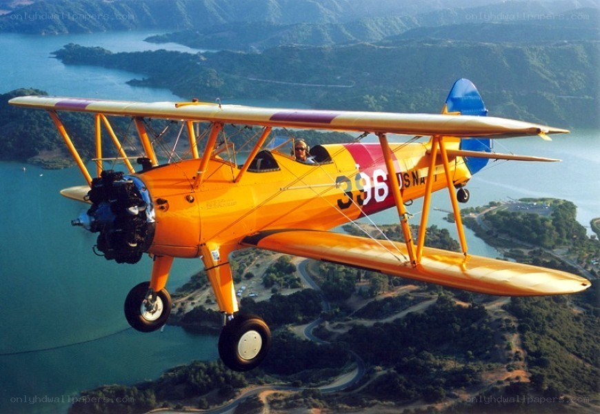 orange biplane in flight