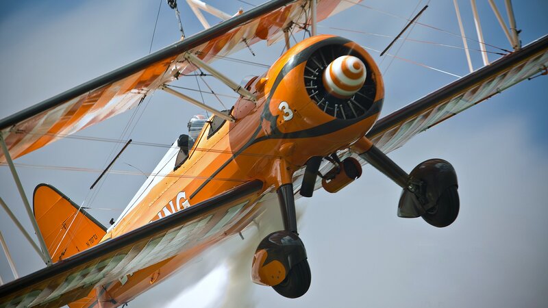 Orange Biplane in Flight — Dynamic