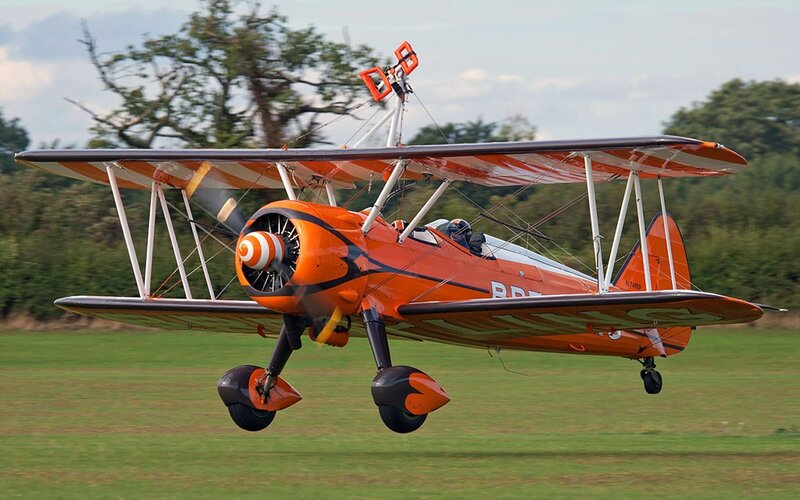 orange biplane in flight