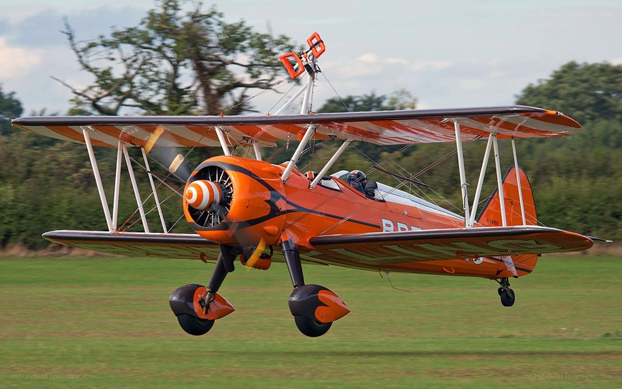 orange biplane in flight
