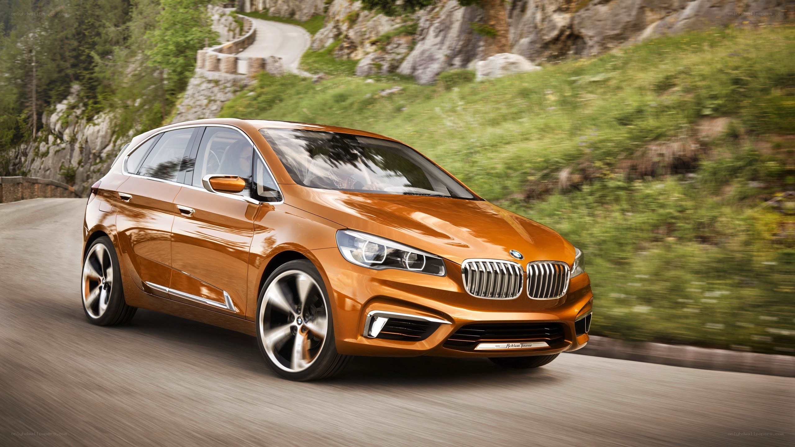 Orange BMW driving on mountain road