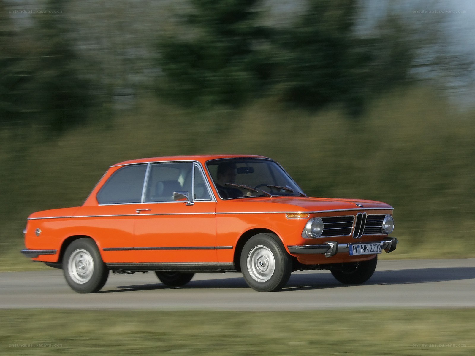 Orange BMW driving on road