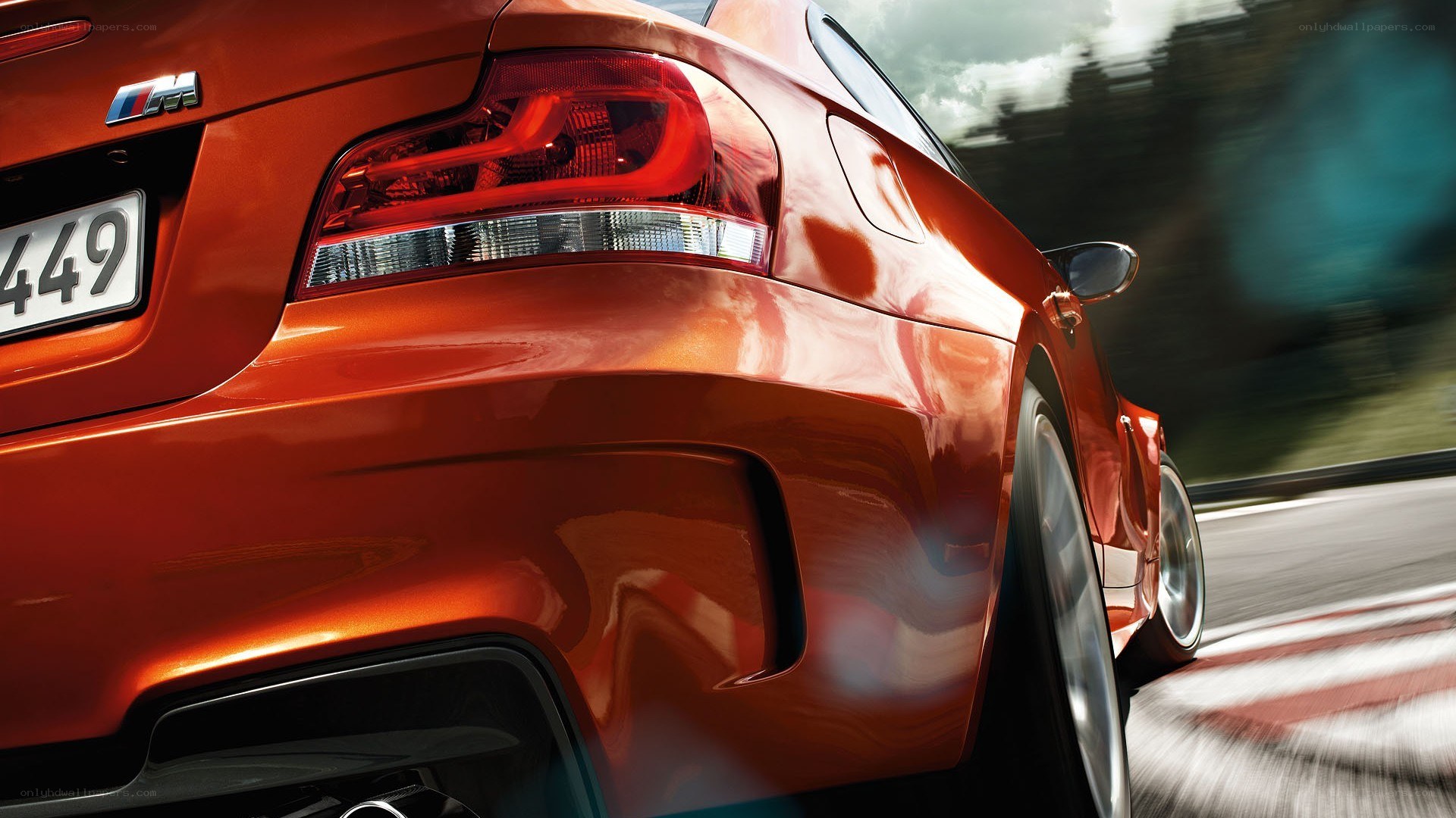 orange BMW M1 driving on track
