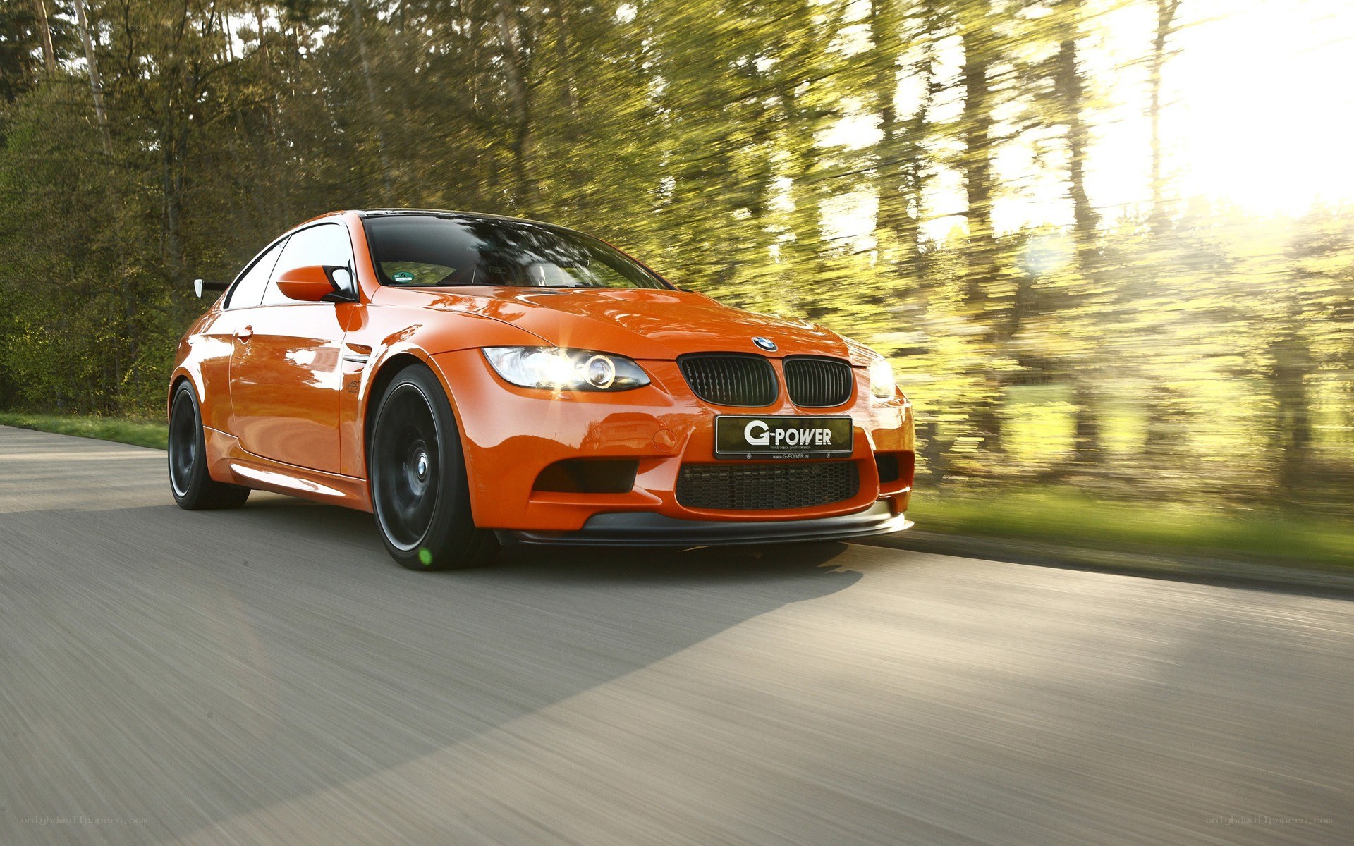 orange BMW M3 in motion