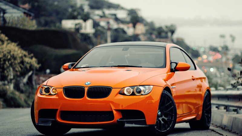 orange bmw m3 on a coastal road
