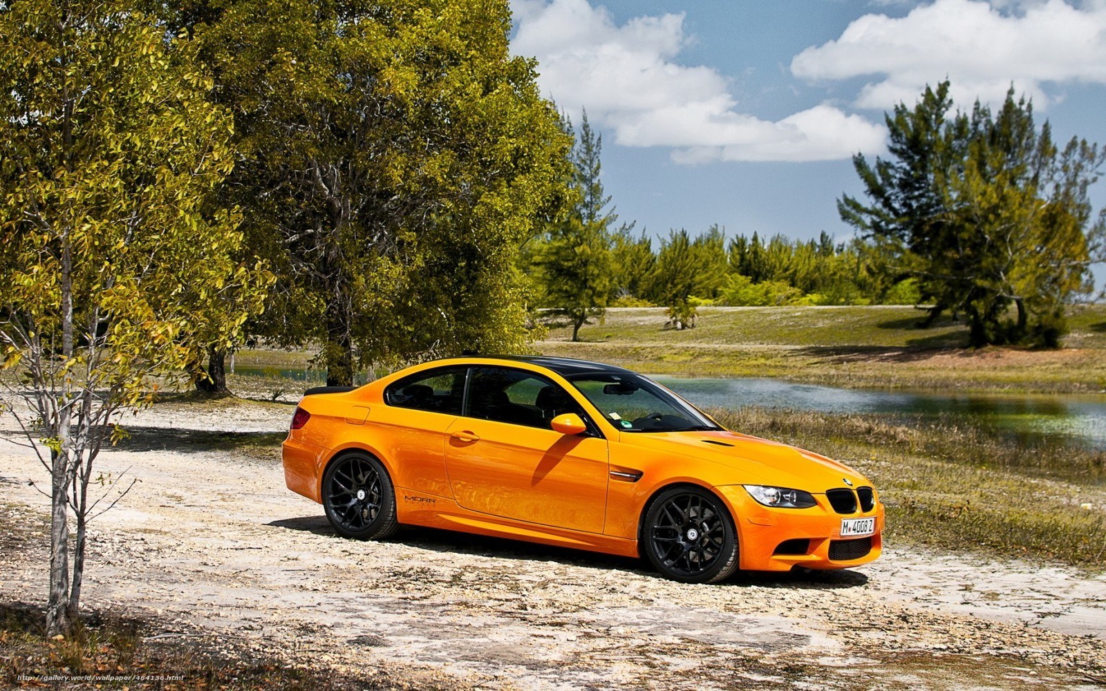 Orange BMW M3 on a dirt path