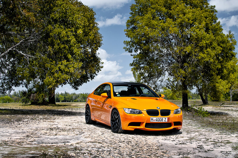 Orange BMW M3 on a gravel path