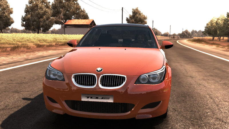 orange bmw m5 on country road