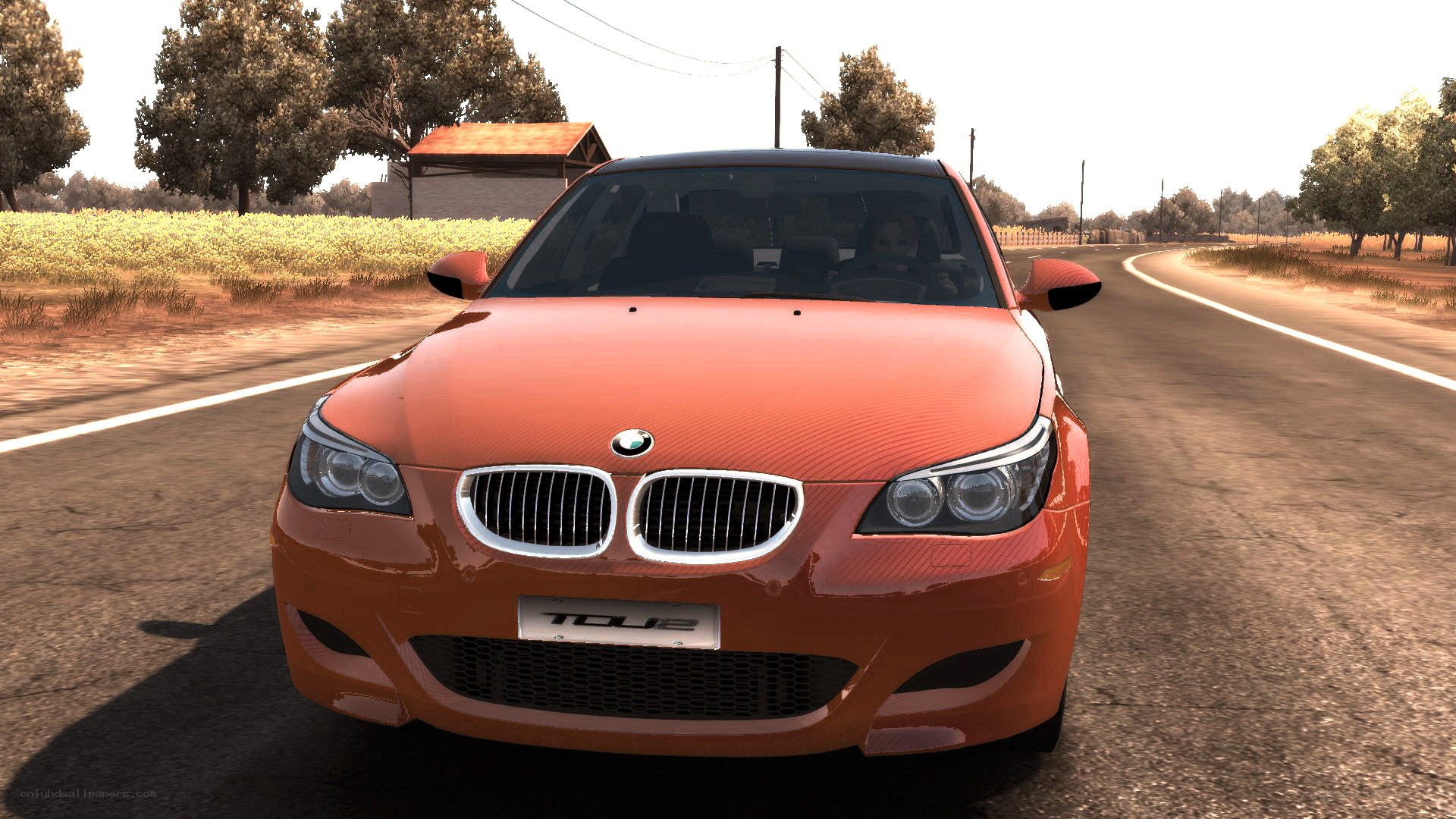 orange bmw m5 on country road