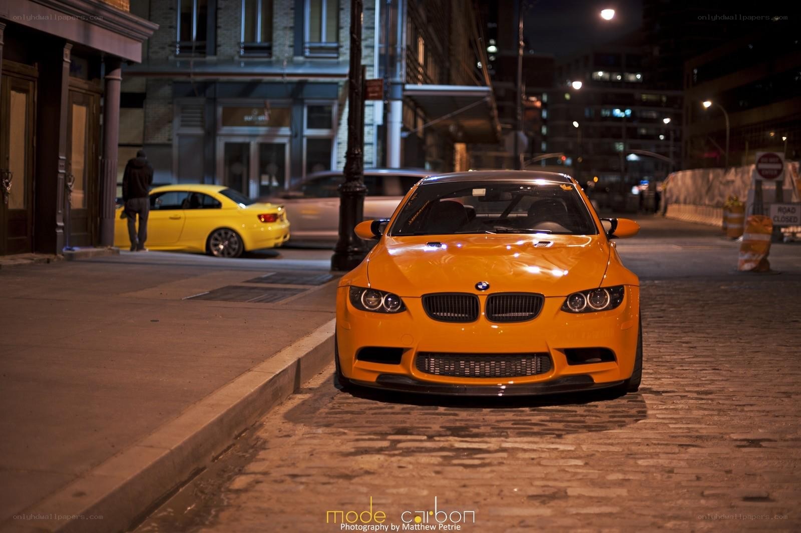 Orange BMW on cobblestone street