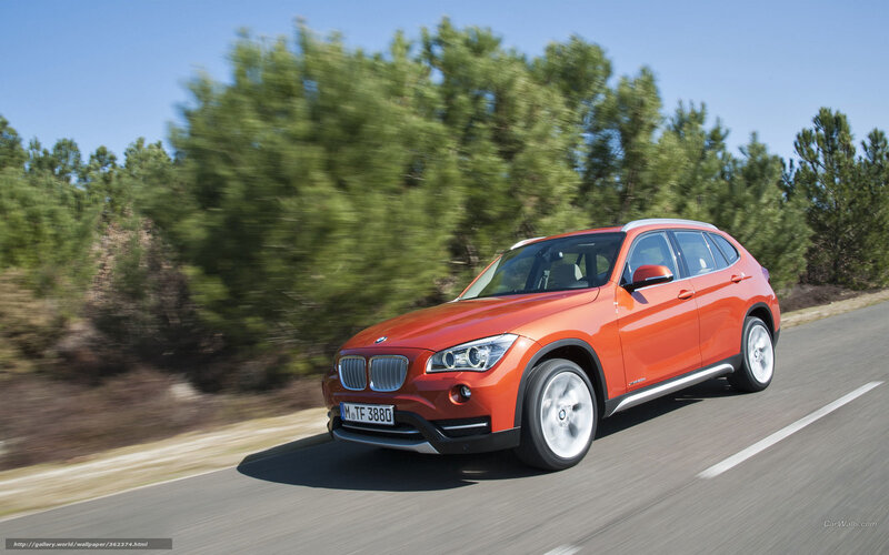 Orange BMW X1 driving on road