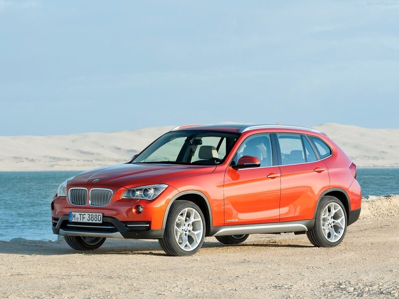 Orange BMW X1 parked by the sea